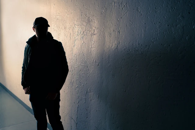 suspicious man standing near wall