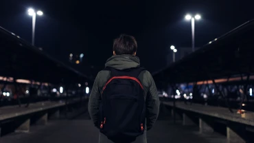 Child with backpack on a dark night